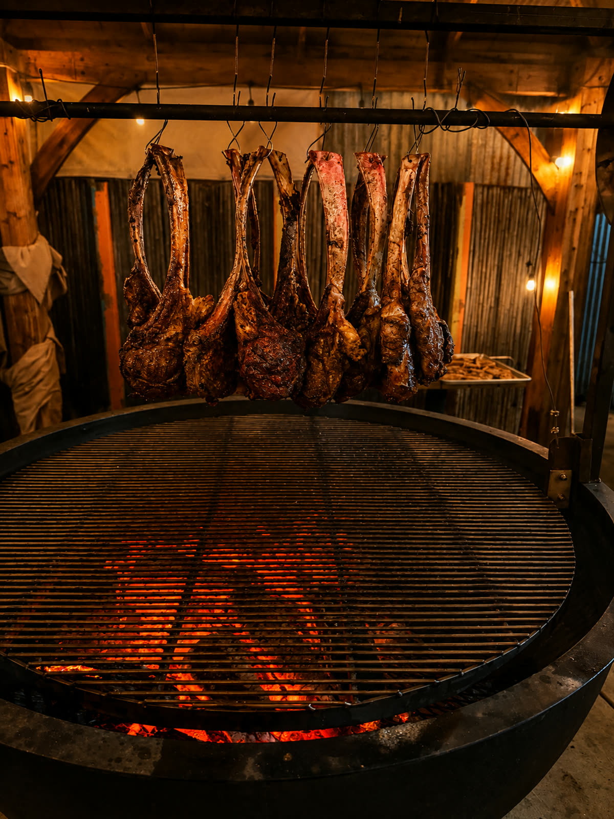 Tomahawk steaks hanging over the open grill under string lights